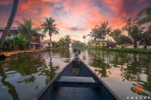 una barca che percorre un canale con palme di Zostel Alleppey a Alleppey Altre 42 foto