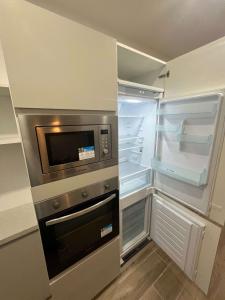 cocina con nevera vacía y microondas en Qawra Seaside Birch Leaf, en St Paul's Bay