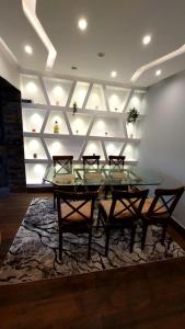 een eetkamer met een glazen tafel en stoelen op een tapijt bij Private villa in Sheikh Zayed