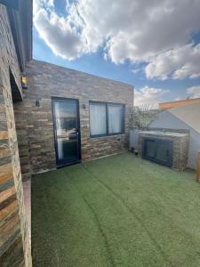 een achtertuin met een gazon en een gebouw bij Private villa in Sheikh Zayed