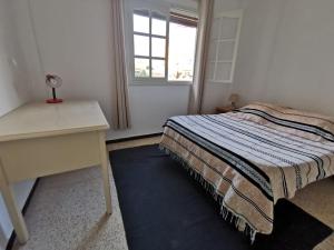 Oasis de calme Sousse centre في Bin Rhilouf: غرفة نوم بها سرير ومكتب ونافذة