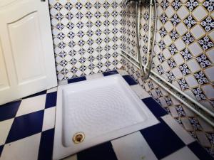 Oasis de calme Sousse centre في Bin Rhilouf: حمام بباب أبيض وأرضية مربعة +3 صور