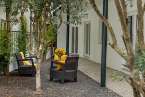 um grupo de cadeiras em um pátio com árvores em Glória Suites Hotel em Lisboa