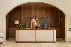 a man talking on a phone at a reception desk at The Yard Corfu Boutique Hotel and Spa in Moraitika +120 photos