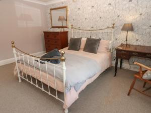 a bedroom with a white bed and a wooden desk at Daleholme in Barnard Castle