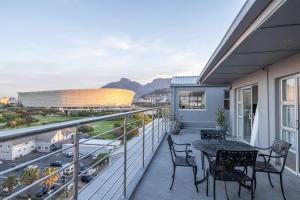 een balkon met een tafel en stoelen en uitzicht bij Atlantic Sky Penthouses - Breathtaking Views in Kaapstad
