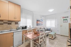 a kitchen and living room with a table and a couch at Geani in La Marina +10 photos