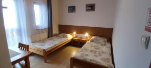 a small room with two beds and a window at Pokoje Gościnne VEIKSME in Bestwina