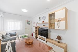 a living room with a table and a tv at Geani in La Marina