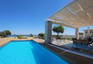 a swimming pool with a pergola next to a house at Gennadi Villa Mary in Gennadi