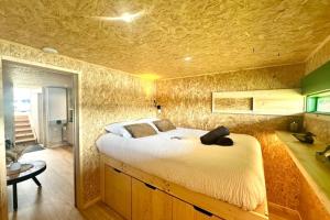 ein Schlafzimmer mit einem großen Bett in einem Zimmer in der Unterkunft Les 1000 Ailes-Expérience Unique dans une Hutte in Le Crotoy