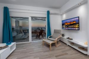 a living room with a tv and a chair at Gennadi Villa Mary in Gennadi