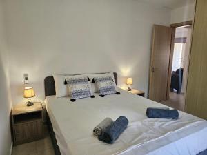 ein Schlafzimmer mit einem großen weißen Bett mit blauen Kissen in der Unterkunft Horizon View 2 in Kiti