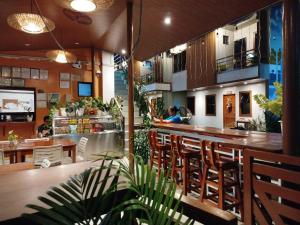 a restaurant with a bar with wooden tables and chairs at BALAI MALINAWON Hotel 3 in General Luna