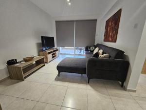 ein Wohnzimmer mit Sofa und Fernseher in der Unterkunft Horizon View 2 in Kiti