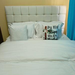 基苏木Makasembo Estate的一张带枕头的白色床和上面的标志