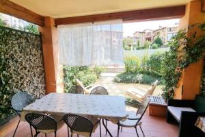 a patio with a table and chairs and a window at Borgo del Torchio H3 ByBookinggardalake in Manerba del Garda