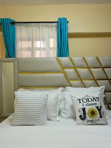 基苏木Makasembo Estate的一张带白色枕头和蓝色窗帘的床