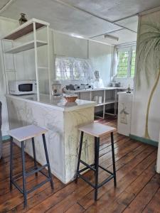 eine Küche mit einer Theke und 2 Hockern in der Unterkunft Kitengela Cabin in Kajiado