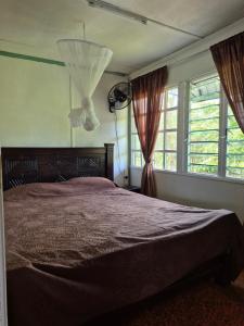 ein Schlafzimmer mit einem großen Bett und zwei Fenstern in der Unterkunft Kitengela Cabin in Kajiado
