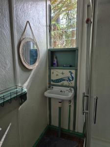 ein Badezimmer mit Waschbecken und Spiegel in der Unterkunft Kitengela Cabin in Kajiado + 37 Fotos