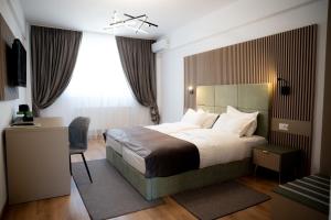 a hotel room with a large bed and a window at Hotel Dumbrava in Rupea +30 photos