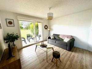 a living room with a couch and a table at Appartement neuf proche Guingamp in Ploumagoar