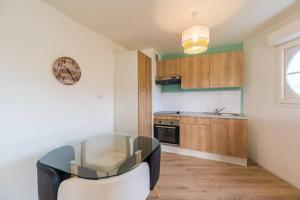 a small kitchen with a glass table in a room at Appartement neuf proche Guingamp in Ploumagoar
