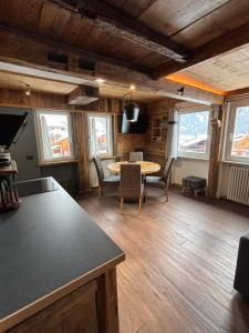 een woonkamer met een tafel en stoelen bij La Tana dell'Orso in Campitello di Fassa