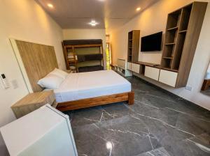 Una pequeña habitación con una cama y un televisor. en Complejo Ysyry Cabañas Eldorado Misiones, en Puerto Victoria 50 fotos más