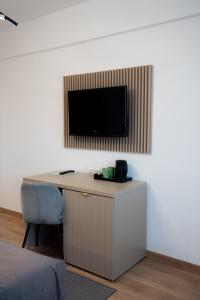 a room with a desk with a television on a wall at Hotel Dumbrava in Rupea