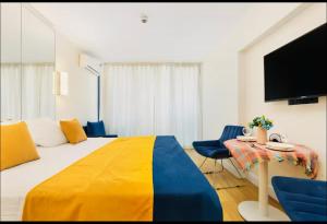 Una habitación de hotel con una cama y una mesa con sillas. en ORBI CITY - Seaside Apartments, en Batumi