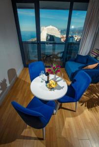 una mesa y sillas en una habitación con vistas en ORBI CITY - Seaside Apartments, en Batumi