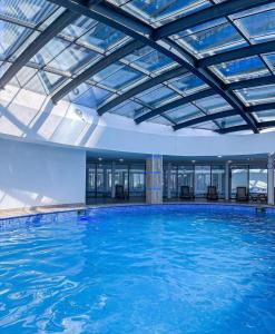 una gran piscina con techo de cristal en ORBI CITY - Seaside Apartments, en Batumi