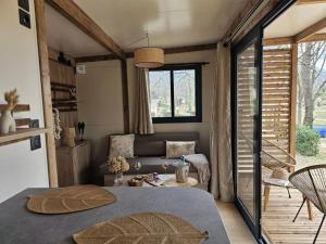 a living room with a bed and a couch at ZEcamping 3 étoiles vue lac environnement calme in Douville +110 photos