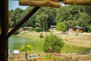 a view of a lake with a playground at ZEcamping 3 étoiles vue lac environnement calme in Douville