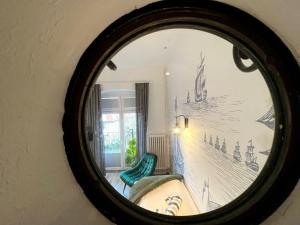 a mirror reflecting a room with a green chair at Kapitaenshaus-Lassen-Zimmer-Sindbad in Westerland (Sylt)