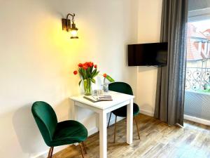 a room with a table and two chairs and a vase of flowers at Kapitaenshaus-Lassen-Zimmer-Sindbad in Westerland (Sylt) +7 photos