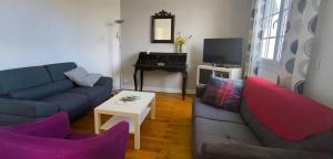a living room with a couch and a table at Gite 10pers, Piscine couverte, CRITEUIL,Charente in Criteuil-la-Magdeleine