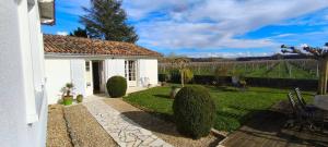 a white house with a yard with bushes at Gite 10pers, Piscine couverte, CRITEUIL,Charente in Criteuil-la-Magdeleine