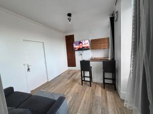 a living room with a couch and a tv on the wall at Super appartement in Malesherbes