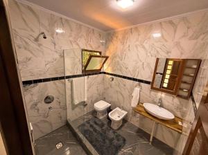 a bathroom with a shower and a toilet and a sink at Complejo Ysyry Cabañas Eldorado Misiones in Puerto Victoria +50 photos