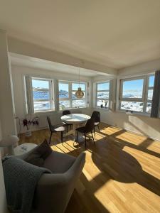 a living room with a couch and a table and chairs at Sallinnguit in Sisimiut