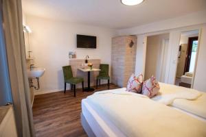 BermuthshainDeutsches Haus Hotel Restaurant Gastwirtschaft Biergarten am Radweg Bermuthshain的一间卧室配有一张床、一个水槽和一张桌子