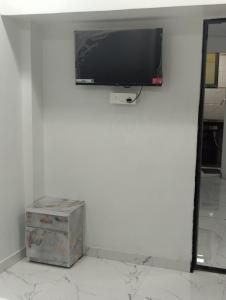 een flatscreen-tv aan een witte muur bij A R Residency in Navi Mumbai +12 foto's