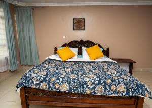 ein Schlafzimmer mit einem Bett mit gelben Kissen in der Unterkunft Private home near JKIA Airport in Nairobi