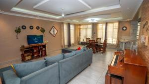 ein Wohnzimmer mit einer blauen Couch und einem Fernseher in der Unterkunft Private home near JKIA Airport in Nairobi