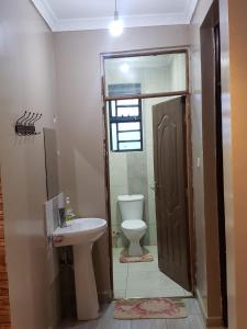 ein Badezimmer mit Toilette und Waschbecken in der Unterkunft Private home near JKIA Airport in Nairobi + 25 Fotos