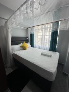 基苏木Peaceful Haven的一张白色的床,配有黄色枕头和窗户