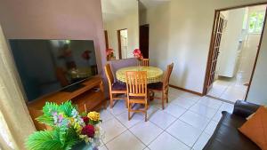 a dining room with a table and chairs and a television at Excelente Apartamento Climatizado em Jacaraipe in Serra